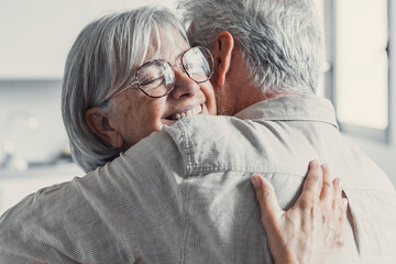 Happy mature couple in love embracing, laughing grey haired husband and wife with closed eyes,...