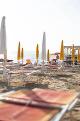 Beach on a summer day with sun beds and umbrellas by the seashore