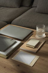Work at home concept. Laptop computer, tablet pad, notebooks, paper sheets, glass of water on...