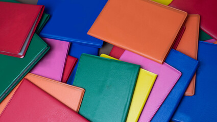small notebooks, various colors, arranged in an irregular manner, filling the background