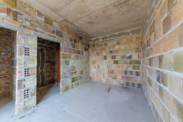 Unfinished room interior of building under construction. Brick walls. New home.