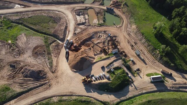 Aerial view of the sorting station on the territory of a sand quarry. Moving trucks loaded with sand
