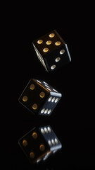 A pair of thrown dices on the reflective surface against dark background