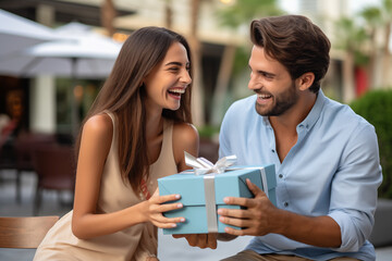 Adult couple at outdoors holding a gift