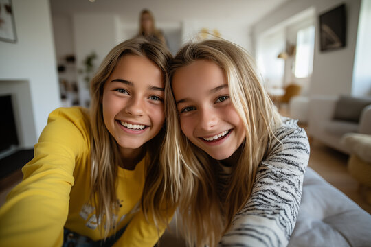 Two teenager girl friends in a house making a selfie