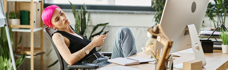 pink haired female worker sitting at desk at office looking at computer, business concept, banner