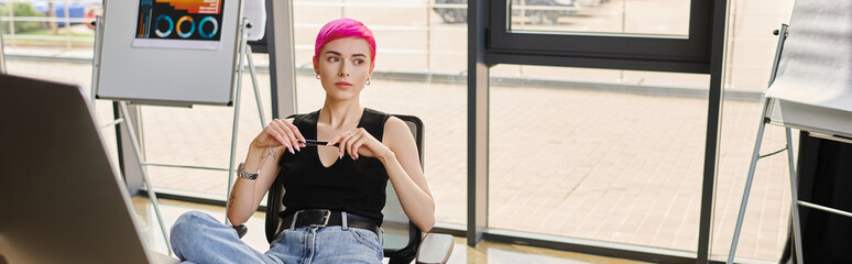 young pink haired businesswoman in casual urban attire sitting by computer at office, banner