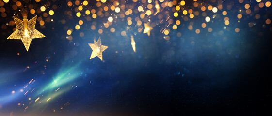 Fototapeta na wymiar Christmas warm gold garland lights over dark background with glitter overlay