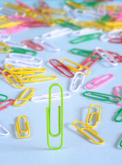 Business concept,team leader, different thinking,leadership and innovation. Group of paper clips and one standing out from the crowd
