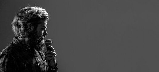 Male singing with microphone. Man in karaoke sings a song into a microphone. Male singing with a microphones. Black and white