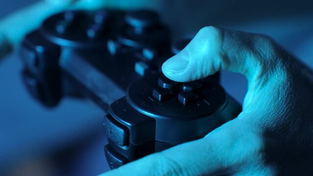 Hand playing on video game controller, close-up