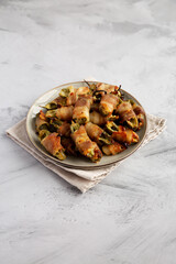 Homemade Bacon-Wrapped Jalapeno Poppers on a Plate, side view.
