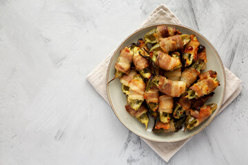Homemade Bacon-Wrapped Jalapeno Poppers on a Plate, top view. Space for text.