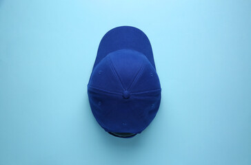 Stylish baseball cap on light blue background, top view