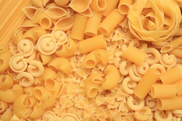 Different types of pasta as background, top view