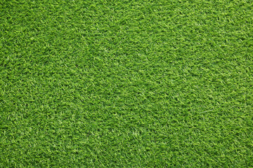 Green artificial grass as background, top view