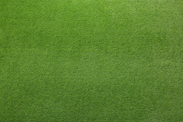 Green artificial grass as background, top view