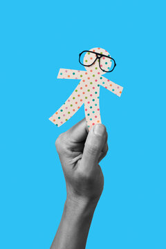 man holding a paper man doll in his hand