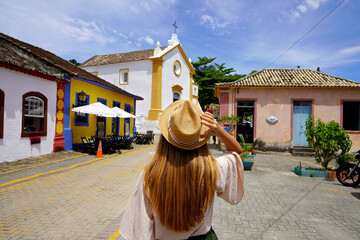 Tourism in Santa Catarina, Brazil. Young traveler woman visiting Santo Antônio de Lisboa historic...