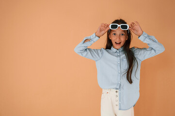 Cute young girl is in the studio against background