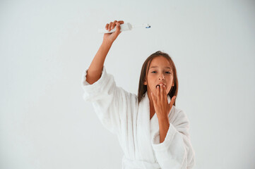 Toothbrush in hand. Conception of beauty and self care. Young girl is in the studio
