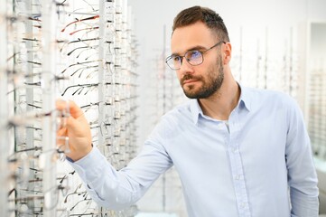 Man choosing glasses in eyewear store