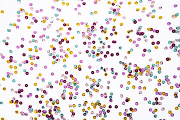 Various colored sequins on a white background.