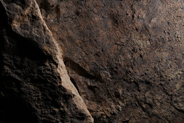 Brown stone texture, dark abstract background. Natural mineral rock close up details, empty backdrop with copy space for design