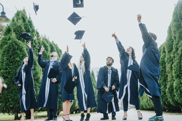 Graduates in gowns and caps celebrate achievements, create memories. Congratulating each other,...
