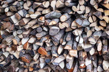 stack of firewood for fireplace at winter time, abstract background close-up. Expensive electricity concept
