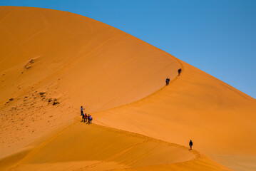People climbing large sand dune, Deadvlei, namib-naukluft national park, namibia