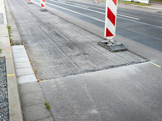 Asphalt milling of a street in the city. The upper layer has been milled down to renew the surface....