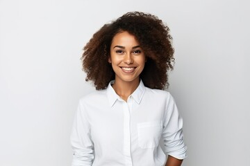 Vertical shot of happy dark skinned female with curly hair, glad to be promoted at work poses indoor against white background
