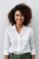 Vertical shot of happy dark skinned female with curly hair, glad to be promoted at work poses indoor against white background