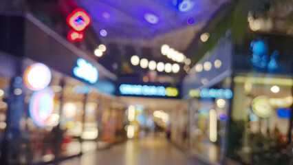 The blurry background of a lively shopping center corridor.