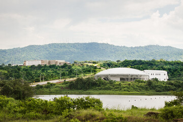 Circular building in the middle of vegetation and next to a lake. Architecture and environment concept.