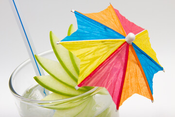 Close up of cocktail with paper umbrella and lemon, aerial view.