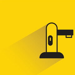 water faucet with shadow on yellow background