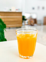 Food and beverage concept. A glass of orange juice on a white table in cafe.