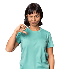 Fototapeta premium Young Hispanic woman with short black hair in studio showing thumb down, disappointment concept.