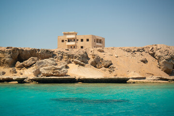 Stone building on the deserted shore of the turquoise sea