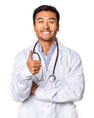 Young Chinese man as a medical doctor in studio smiling and raising thumb up
