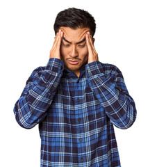 Young Chinese man in studio background touching temples and having headache.