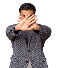 Young Chinese man in studio background doing a denial gesture