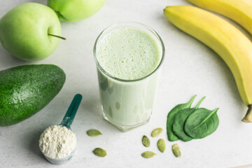Green detox smoothie, blended vegetarian drink, protein milkshake in a glass from spinach, banana,...
