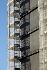 renovation of the external facade of a building, metal scaffolding with protective net - perspective view

