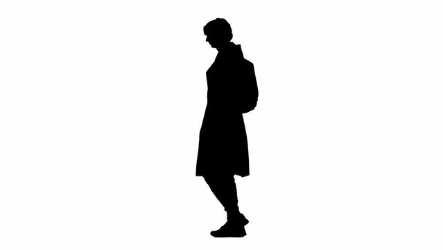Portrait of silhouette traveler isolated on white background alpha channel. Young man walking with rucksack and checking smartphone.