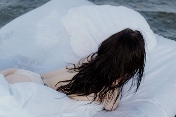 A woman lying on a mattress in the water.