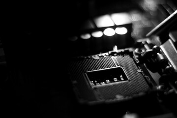closeup of computer mainboard, electronic circuit board, processor board in computer. black and white lighting. blurred background
