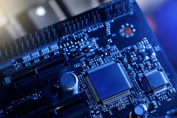 closeup of computer mainboard, electronic circuit board, electrical components in pc. dark blue...